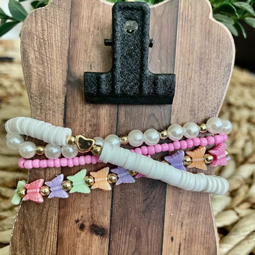 Butterfly stretchable bracelets in pink, purple, and whites. You get all 3. NWOT
